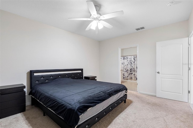 bedroom featuring light colored carpet, ceiling fan, and ensuite bath