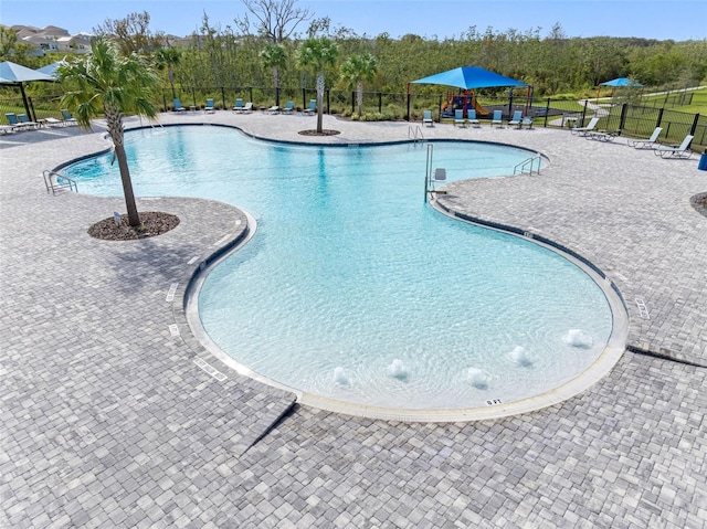 view of swimming pool with pool water feature and a patio area