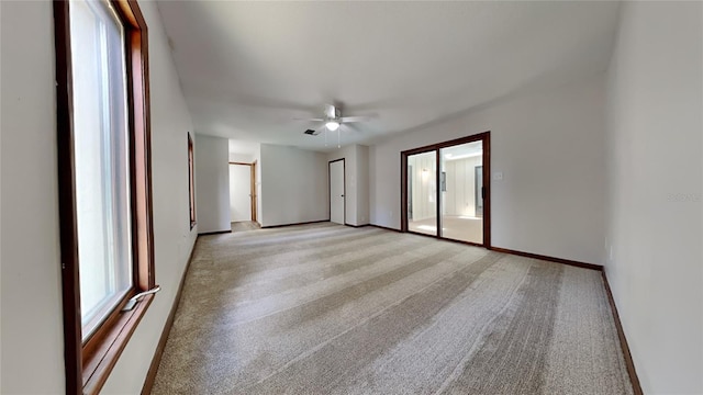 spare room featuring light colored carpet and ceiling fan