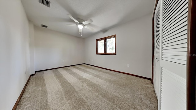 unfurnished bedroom featuring ceiling fan, light carpet, and a closet