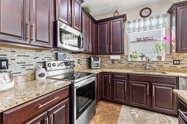 kitchen with stainless steel appliances, light stone countertops, light tile patterned floors, decorative backsplash, and sink