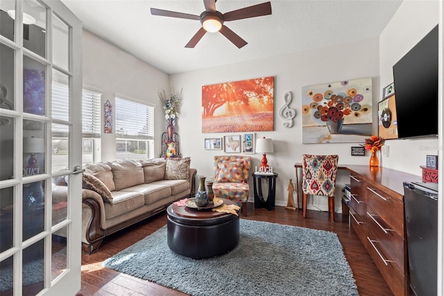 living room featuring ceiling fan, dark hardwood / wood-style flooring, and french doors