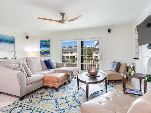 living room featuring a brick fireplace, ceiling fan, and crown molding