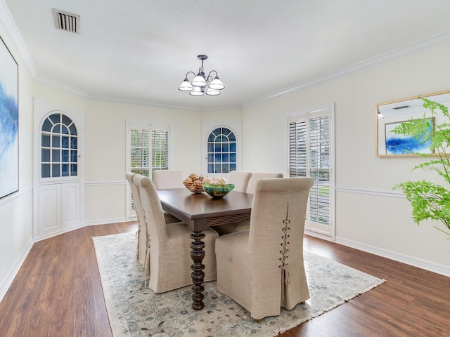 dining space with ornamental molding, dark hardwood / wood-style floors, and an inviting chandelier