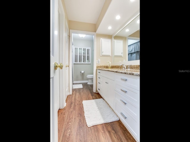 bathroom featuring toilet, vanity, and hardwood / wood-style flooring