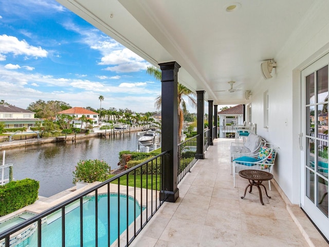 balcony featuring a water view and ceiling fan