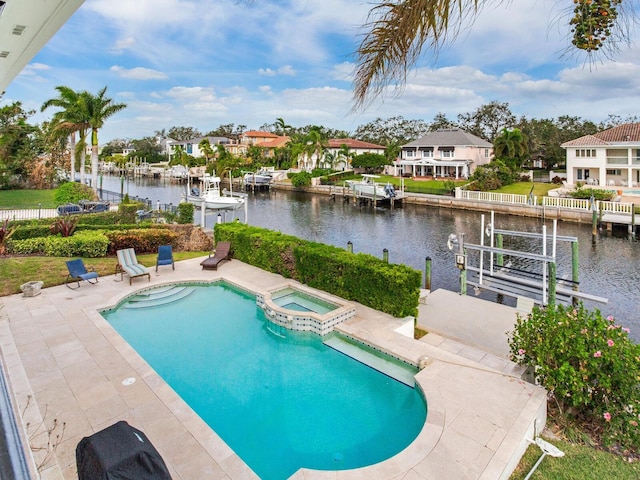 view of swimming pool featuring a patio, an in ground hot tub, and a water view