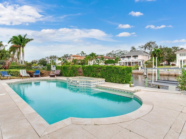 view of pool with an in ground hot tub and a water view