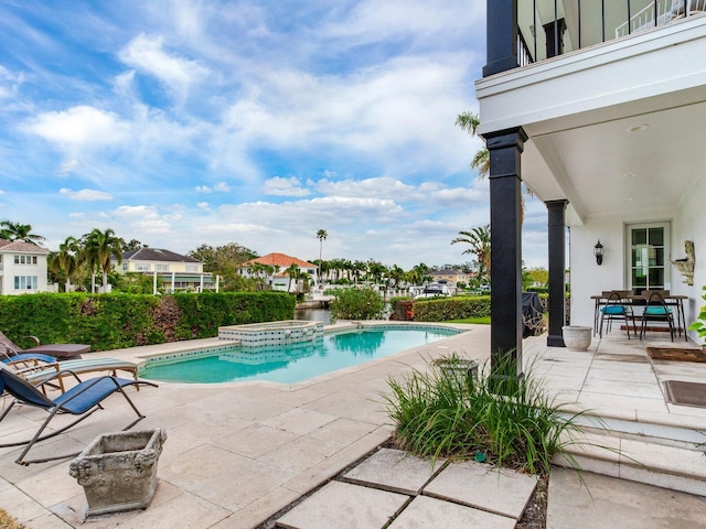 view of pool featuring a patio and an in ground hot tub