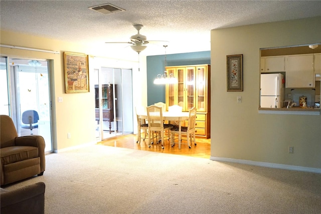 carpeted living room featuring a textured ceiling and ceiling fan