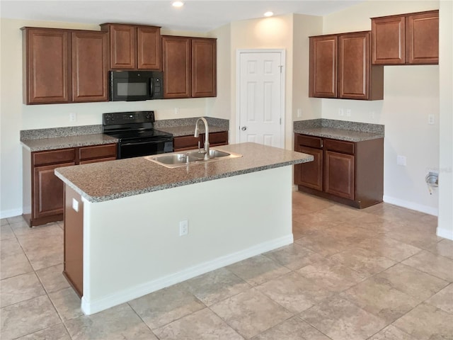 kitchen featuring an island with sink, sink, and black appliances