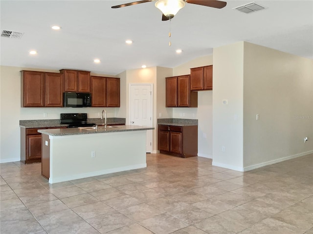 kitchen featuring a center island with sink, dark stone counters, vaulted ceiling, black appliances, and sink