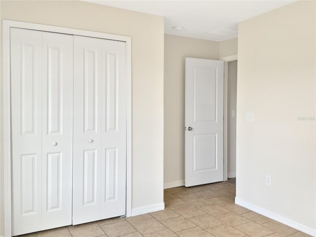 unfurnished bedroom featuring light tile patterned floors and a closet