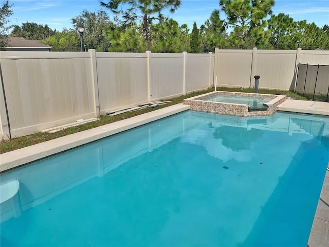 view of swimming pool with an in ground hot tub