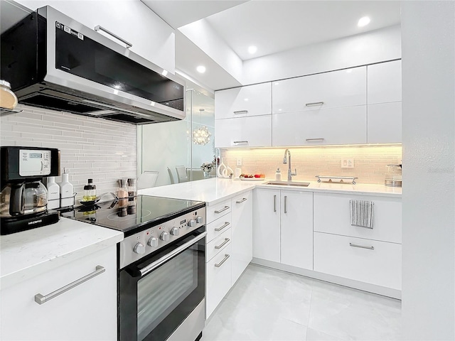 kitchen with stainless steel appliances, white cabinets, sink, tasteful backsplash, and light tile patterned floors