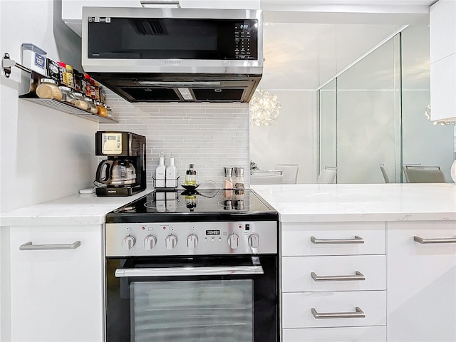 kitchen with backsplash, appliances with stainless steel finishes, light stone counters, and white cabinets