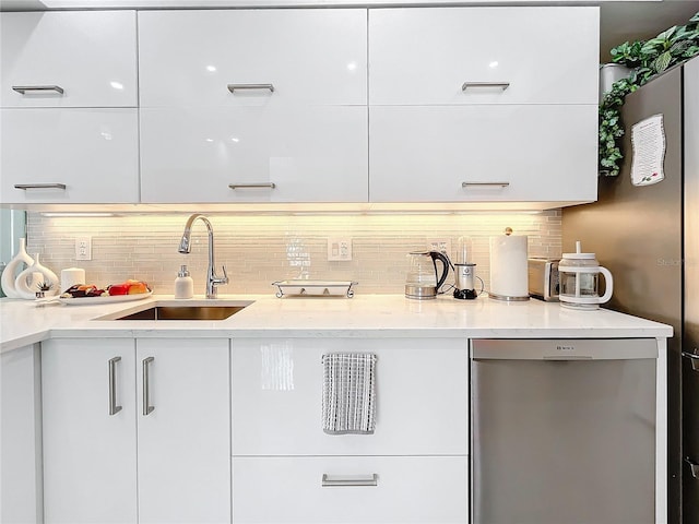 bar featuring dishwasher, tasteful backsplash, white cabinetry, and sink