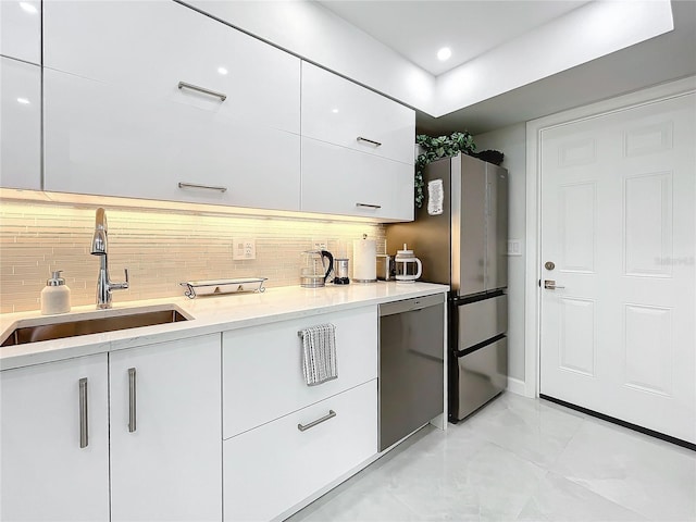 kitchen with white cabinetry, sink, backsplash, and appliances with stainless steel finishes