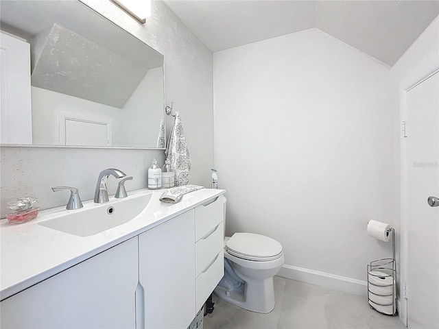 bathroom with vanity, toilet, and lofted ceiling