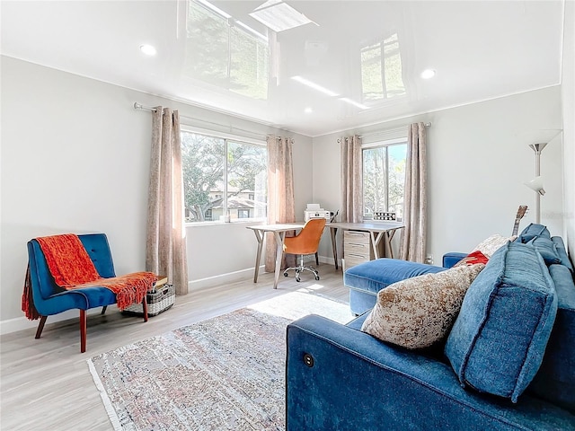 living area featuring light wood-type flooring and crown molding