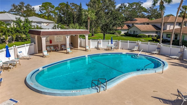 view of pool featuring a patio and a yard