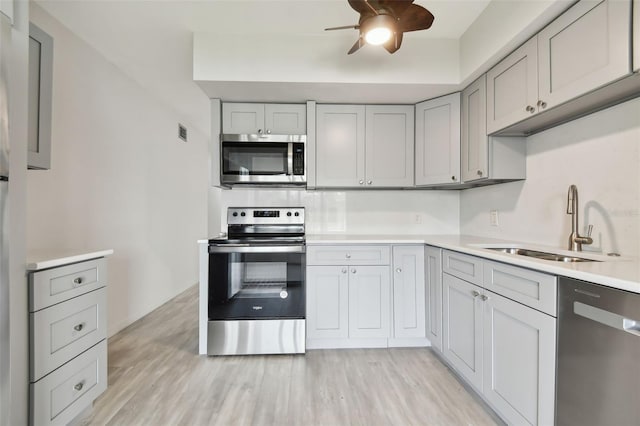 4152 55th Way N Unit 1028, Kenneth City, FL 33709 - kitchen with stainless steel appliances, a sink, light countertops, ceiling fan, and light wood finished floors