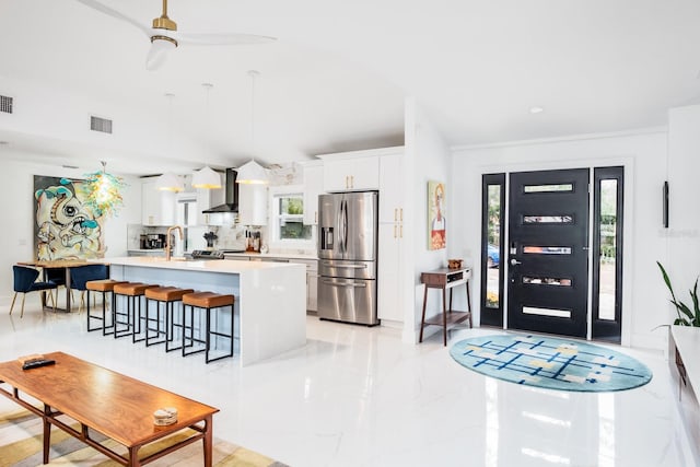 kitchen with white cabinetry, stainless steel refrigerator with ice dispenser, and a wealth of natural light