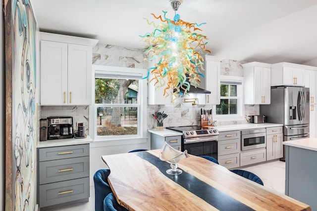 kitchen with white cabinetry, stainless steel appliances, tasteful backsplash, and gray cabinetry