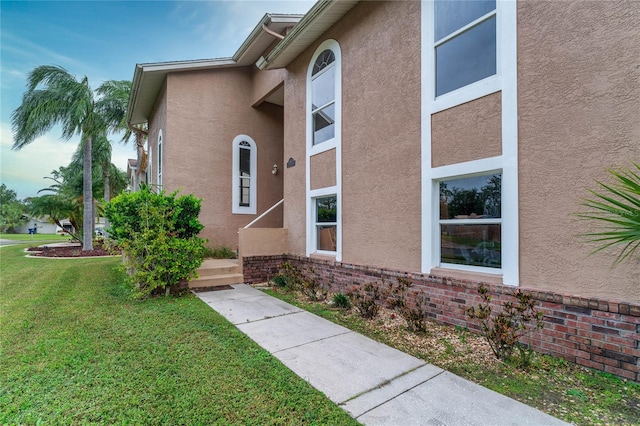 view of exterior entry with a yard