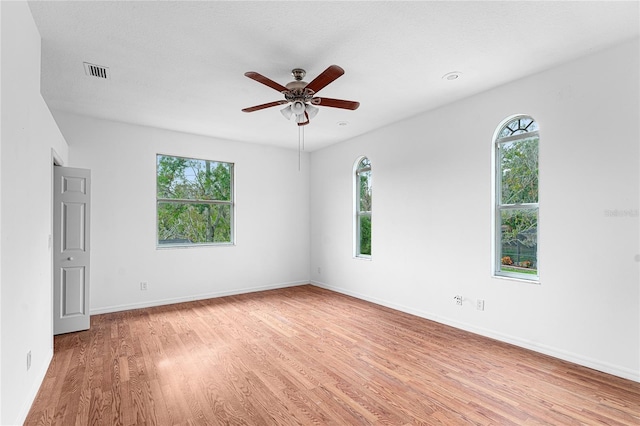 unfurnished room with ceiling fan, light hardwood / wood-style flooring, and a textured ceiling