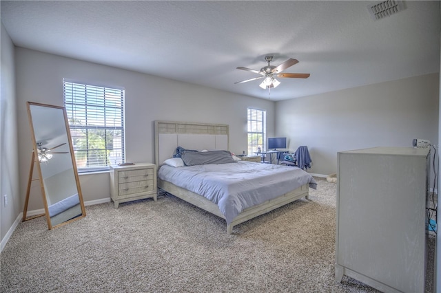 bedroom with ceiling fan, a textured ceiling, and carpet flooring