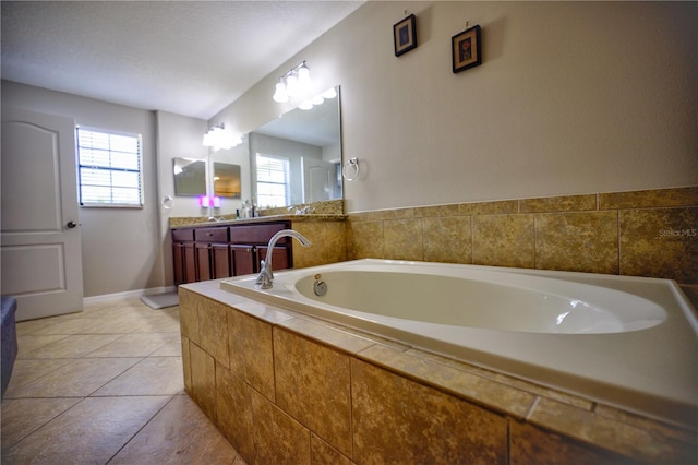 bathroom with vanity, tile patterned flooring, a healthy amount of sunlight, and a relaxing tiled tub