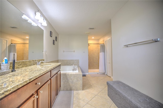 bathroom with vanity, independent shower and bath, tile patterned flooring, and a textured ceiling