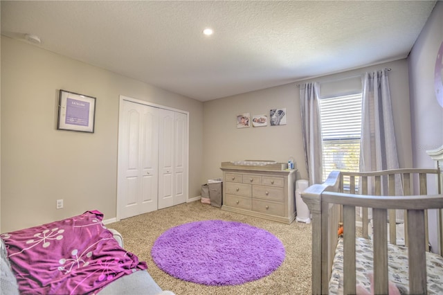 carpeted bedroom featuring a textured ceiling and a closet