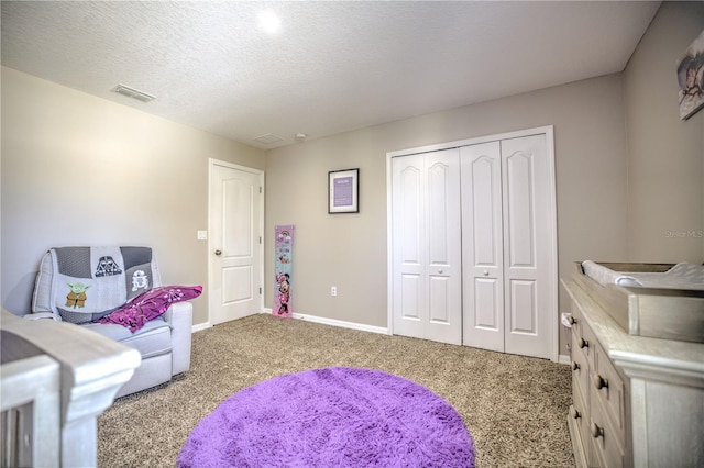 playroom featuring light colored carpet and a textured ceiling