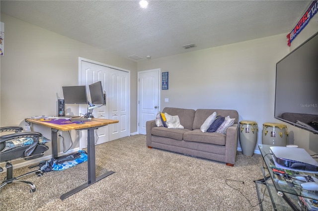 carpeted office space with a textured ceiling