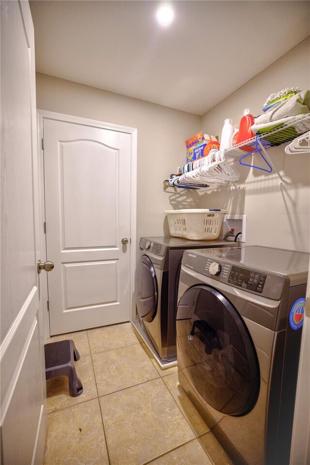 laundry room featuring light tile patterned flooring and washer and dryer