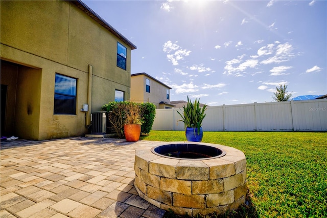 view of patio / terrace with central air condition unit and an outdoor fire pit