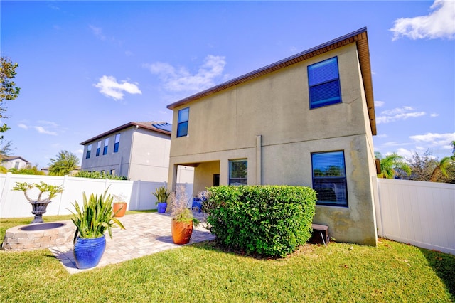 back of property featuring a lawn and a patio area