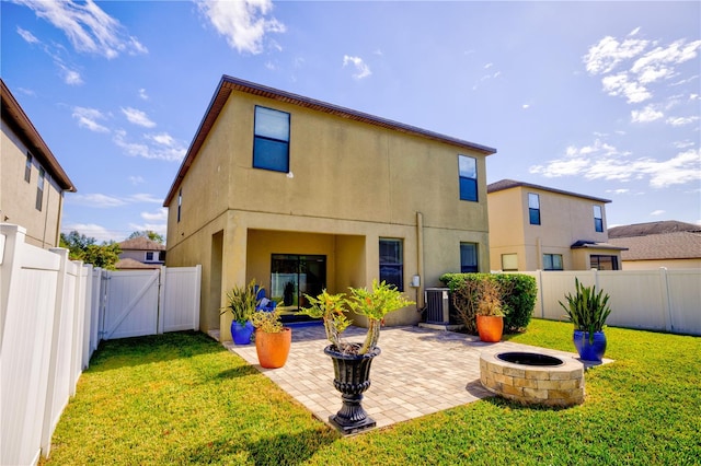 rear view of house featuring central AC unit, a fire pit, a patio, and a yard