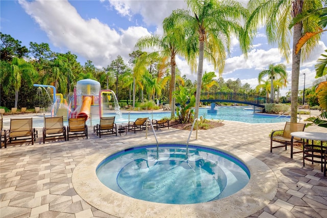 view of swimming pool with a patio, a hot tub, and pool water feature