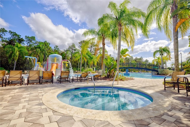 view of swimming pool featuring a hot tub and a patio area