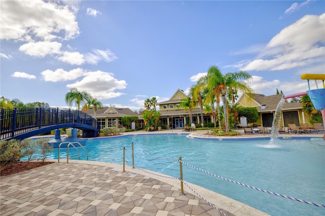 view of pool featuring pool water feature, a water slide, and a patio area