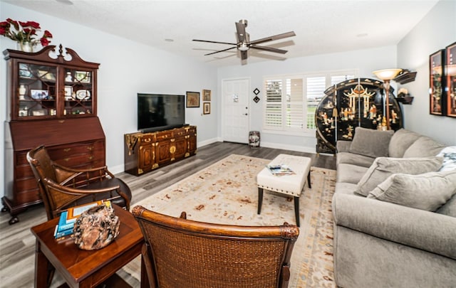 living room featuring ceiling fan and hardwood / wood-style flooring