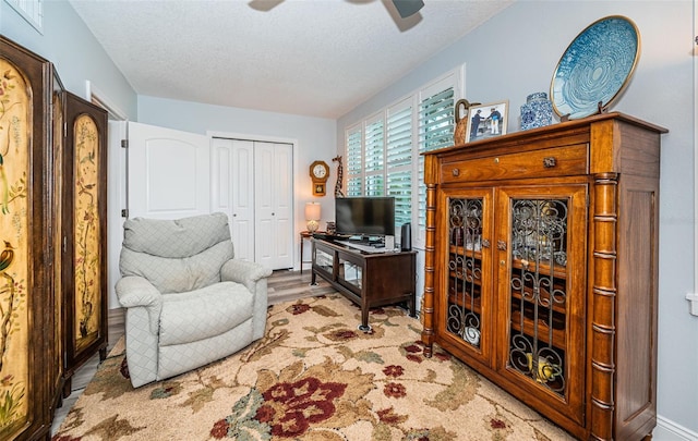 office featuring a textured ceiling, light hardwood / wood-style flooring, and ceiling fan