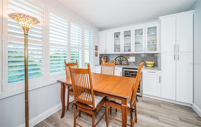 dining space with wine cooler, plenty of natural light, and light hardwood / wood-style flooring