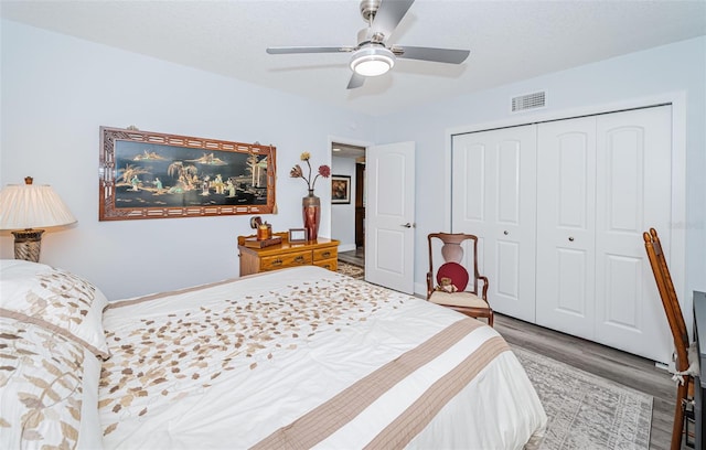 bedroom featuring hardwood / wood-style floors, a closet, and ceiling fan