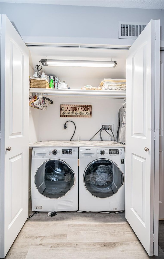 laundry room with separate washer and dryer and light wood-type flooring