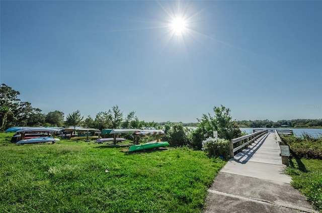 view of property's community featuring a lawn and a water view