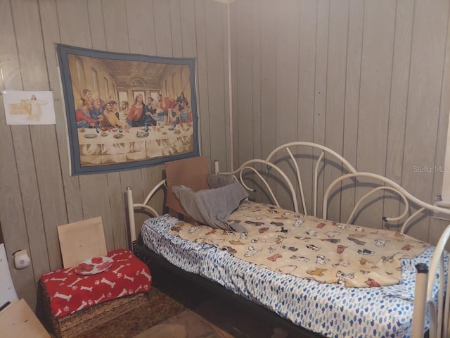 bedroom featuring wood walls